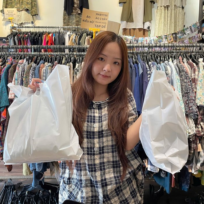 Khách hàng cầm hai túi đồ tại Đô Si La Mi